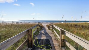 A wooden boardwalk leading to a beach with a drainpipe on it. - Emerald Key 302 by Liquid Life (Orange Beach)