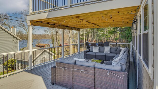 Un espacio de estar al aire libre techado con mobiliario de mimbre y una terraza de madera.