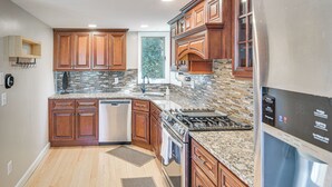 Una cocina moderna con armarios de madera, un refrigerador de acero inoxidable y un salpicadero de azulejos.