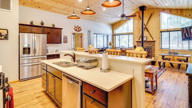 A spacious kitchen with a central island, wooden ceiling, and large windows. - Escape to Alpine! Outstanding Cabin w/ Deck & Yard (Alpine)