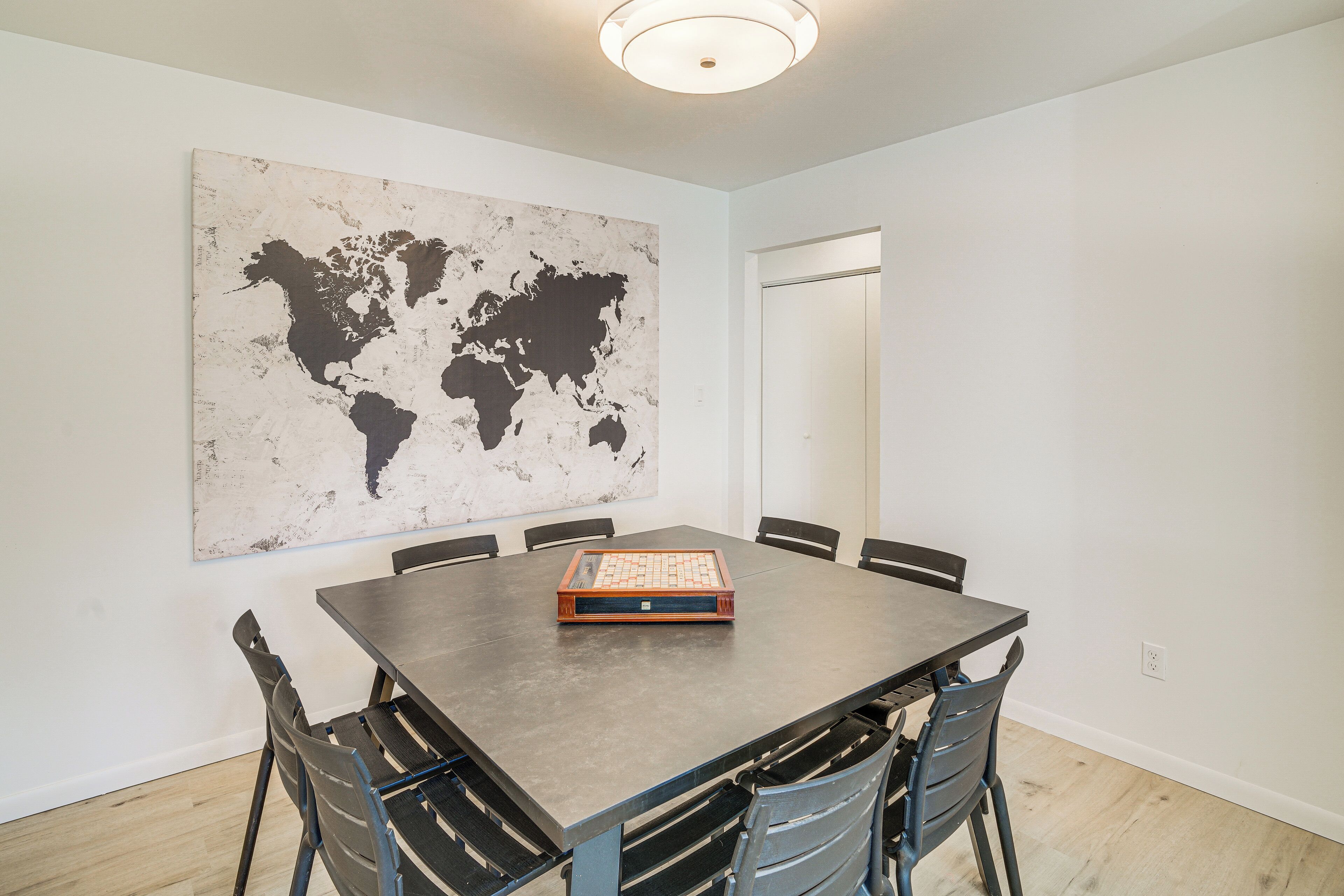 A conference room with a large world map, a rectangular table, and six chairs.