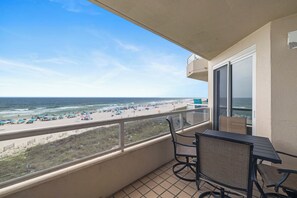 A balcony with a view of the beach, a table, and chairs. - The Enclave 403 by Liquid Life (Orange Beach)