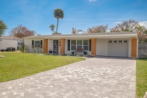 A single-story house with a garage, a front porch, and a paved driveway.