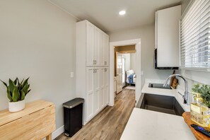 A modern kitchen with a sink, cabinets, and a potted plant. - Easy Trail Access! Container Retreat in Cedar City (Cedar City)