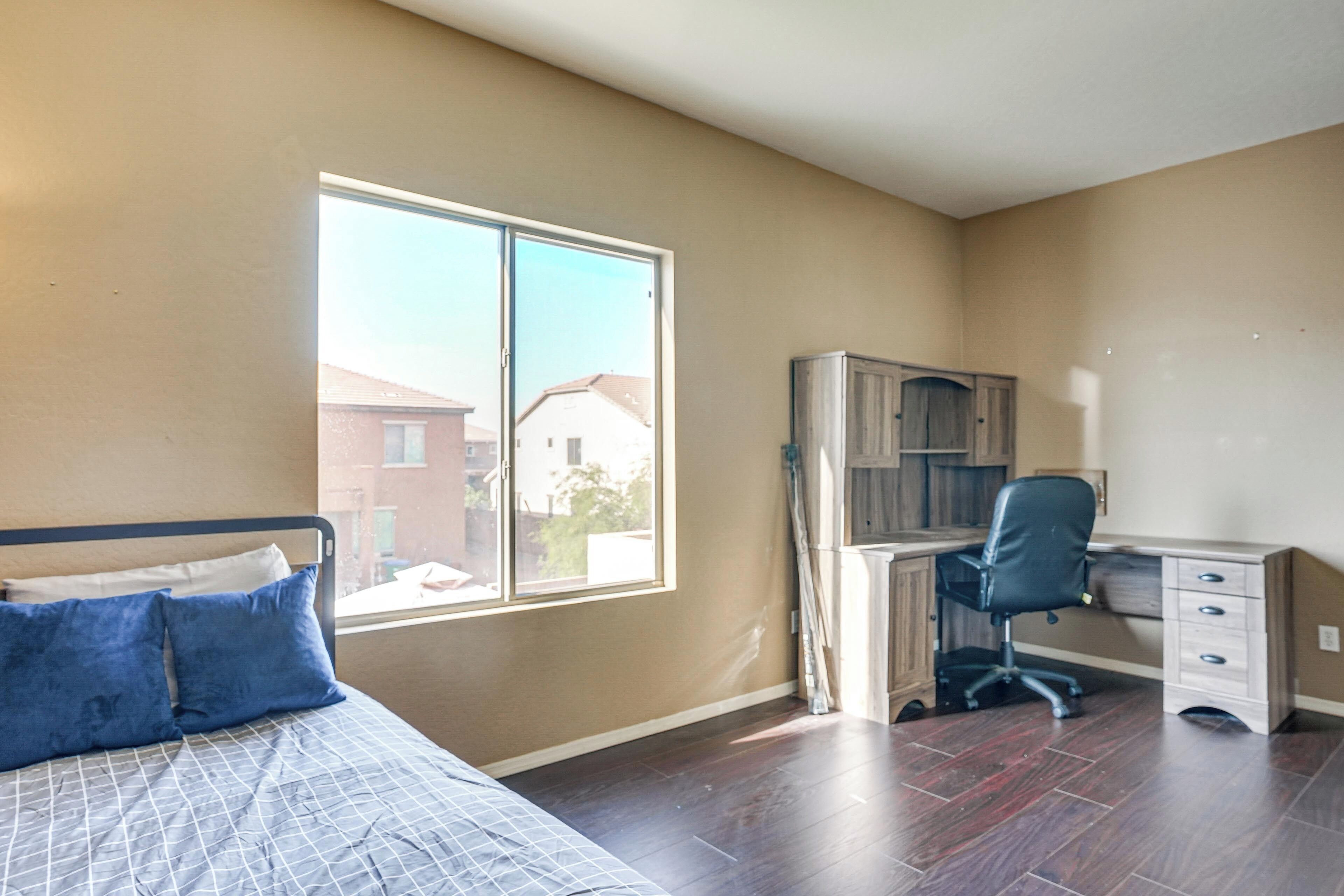 Une chambre à coucher avec un lit, un bureau et une fenêtre.