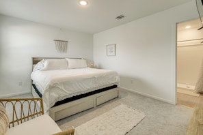 A bedroom with a bed, bedside table, and a wall-mounted light fixture. - Extended Family Getaway! 5 Mi to Gruene District (New Braunfels)