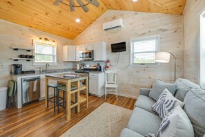 A compact kitchen with wooden walls, a dining area, and a gray sofa. - Fish, Boat, Relax! Quiet Home By Lake Cumberland (Nancy)
