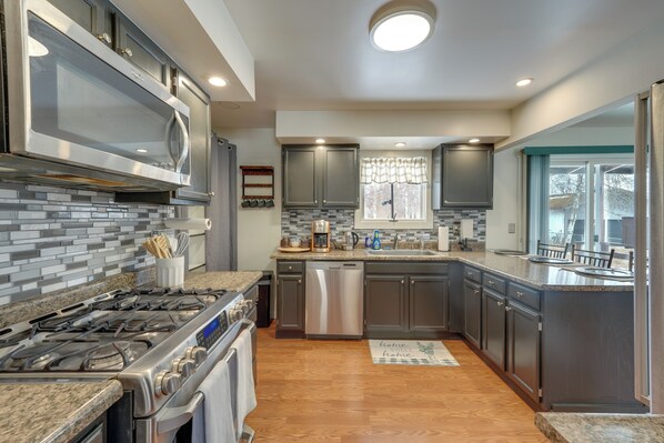A modern kitchen with granite countertops, stainless steel appliances, and a large island.