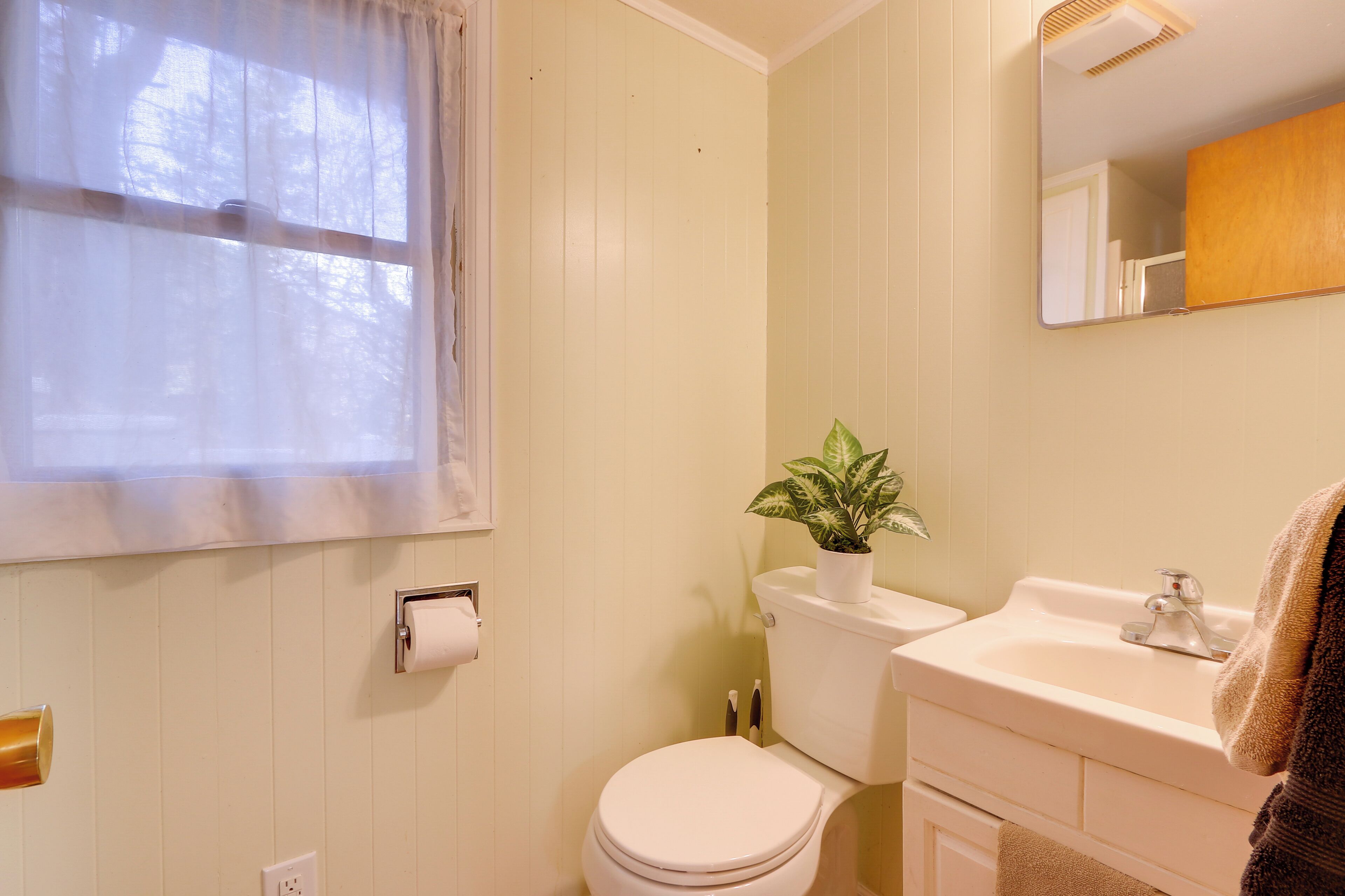 Ein Badezimmer mit Toilette, Waschbecken und Fenster.