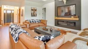 A spacious living room with leather sofas, a flat-screen TV mounted on a wall, and a wooden ceiling. - 1 Mi to Boat Ramp! Lake Placid Home w/ Dock (Lake Placid)