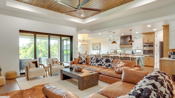 A spacious living area with leather sofas, a coffee table, and a large window. - 1 Mi to Boat Ramp! Lake Placid Home w/ Dock (Lake Placid)