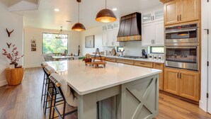 A modern kitchen with a large island, stainless steel appliances, and wooden cabinetry. - 1 Mi to Boat Ramp! Lake Placid Home w/ Dock (Lake Placid)