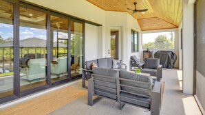 A modern outdoor living area with a sofa, chairs, and a grill. - 1 Mi to Boat Ramp! Lake Placid Home w/ Dock (Lake Placid)