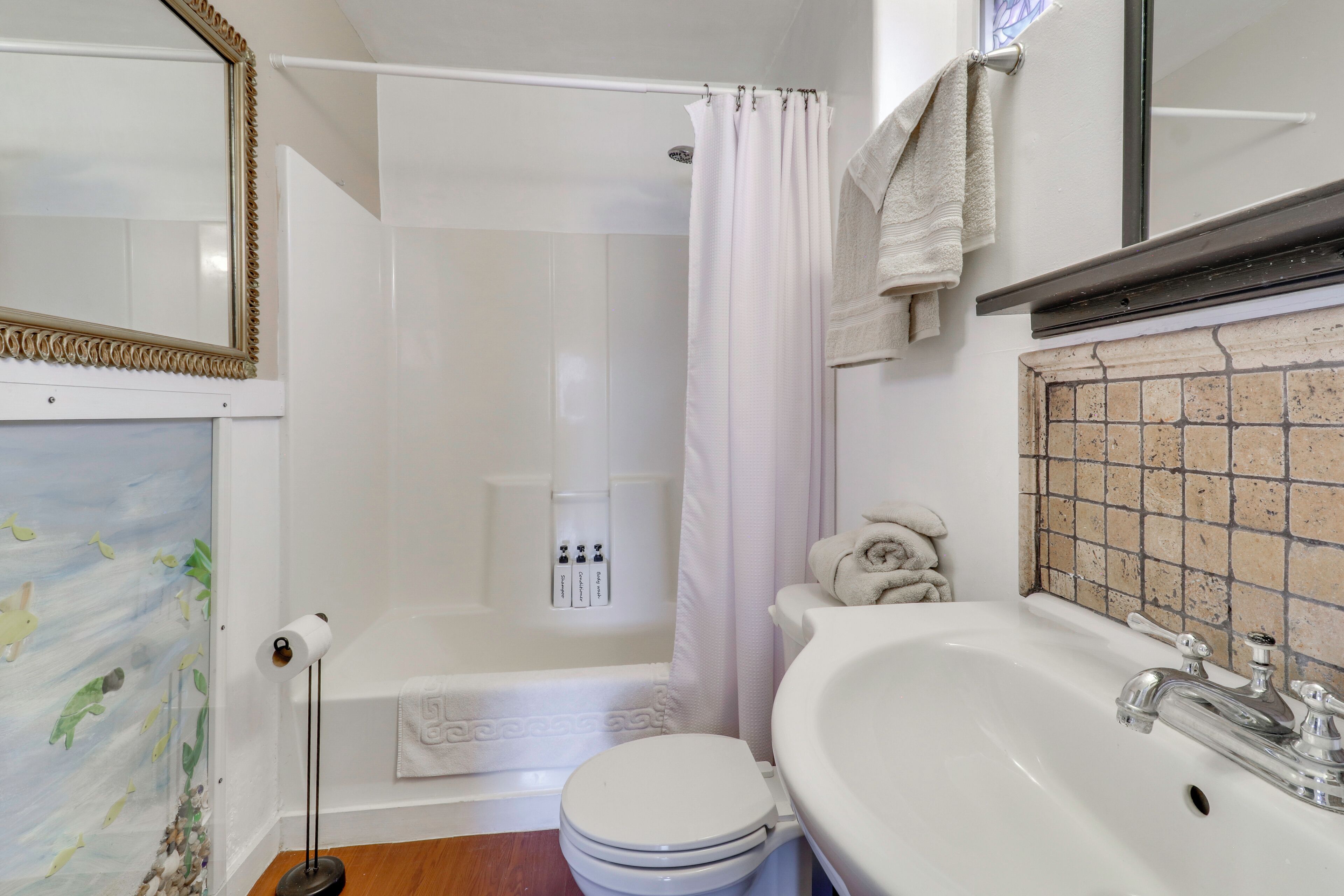 Un baño con bañera, inodoro y lavamanos.