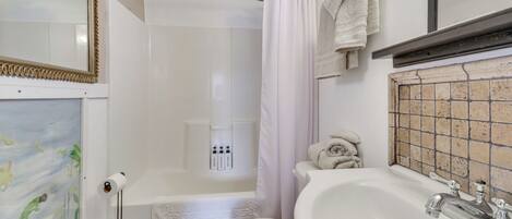 Un baño con bañera, inodoro y lavamanos.