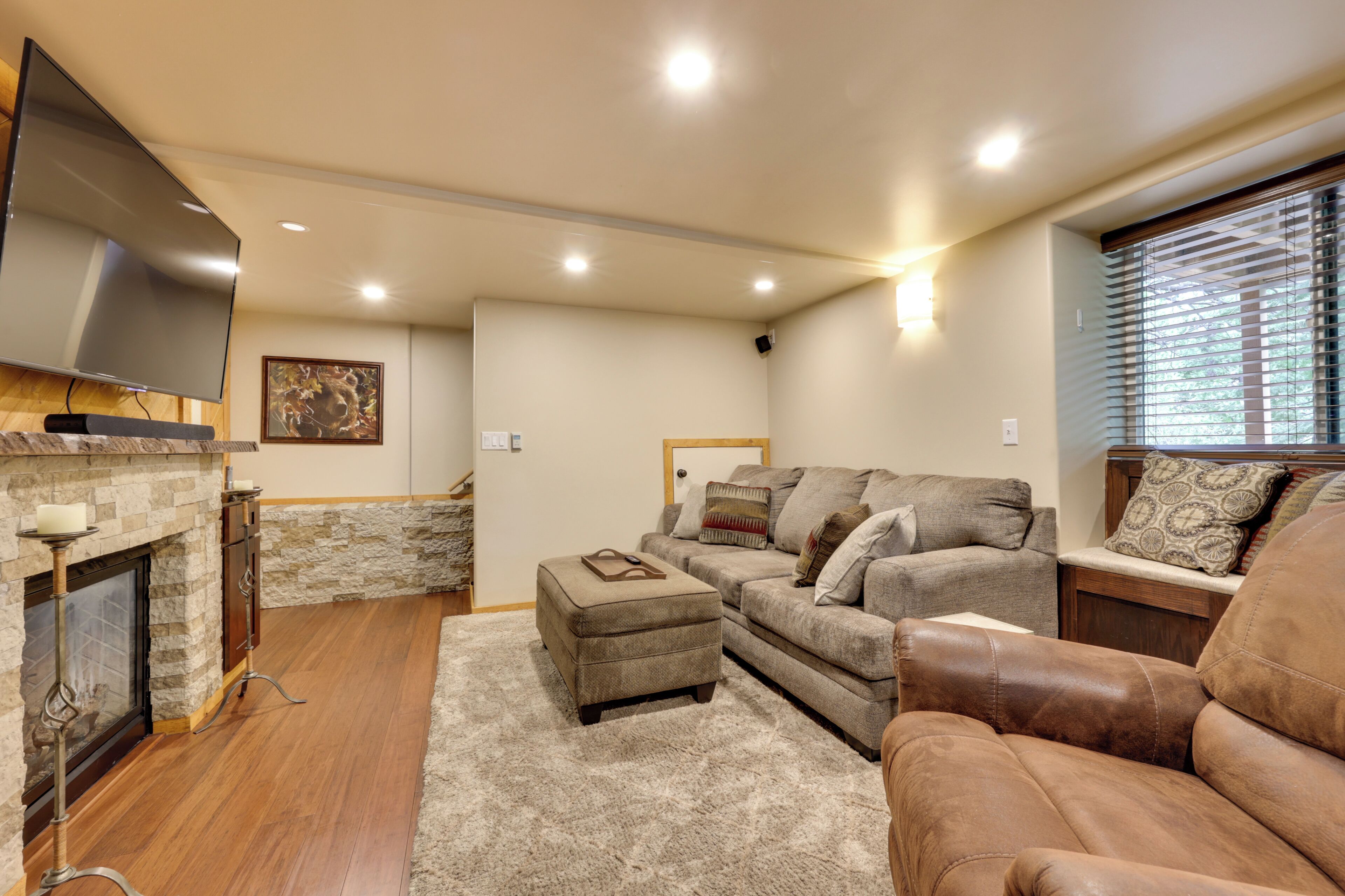A living room with a fireplace, a television, a sofa, and a leather armchair.