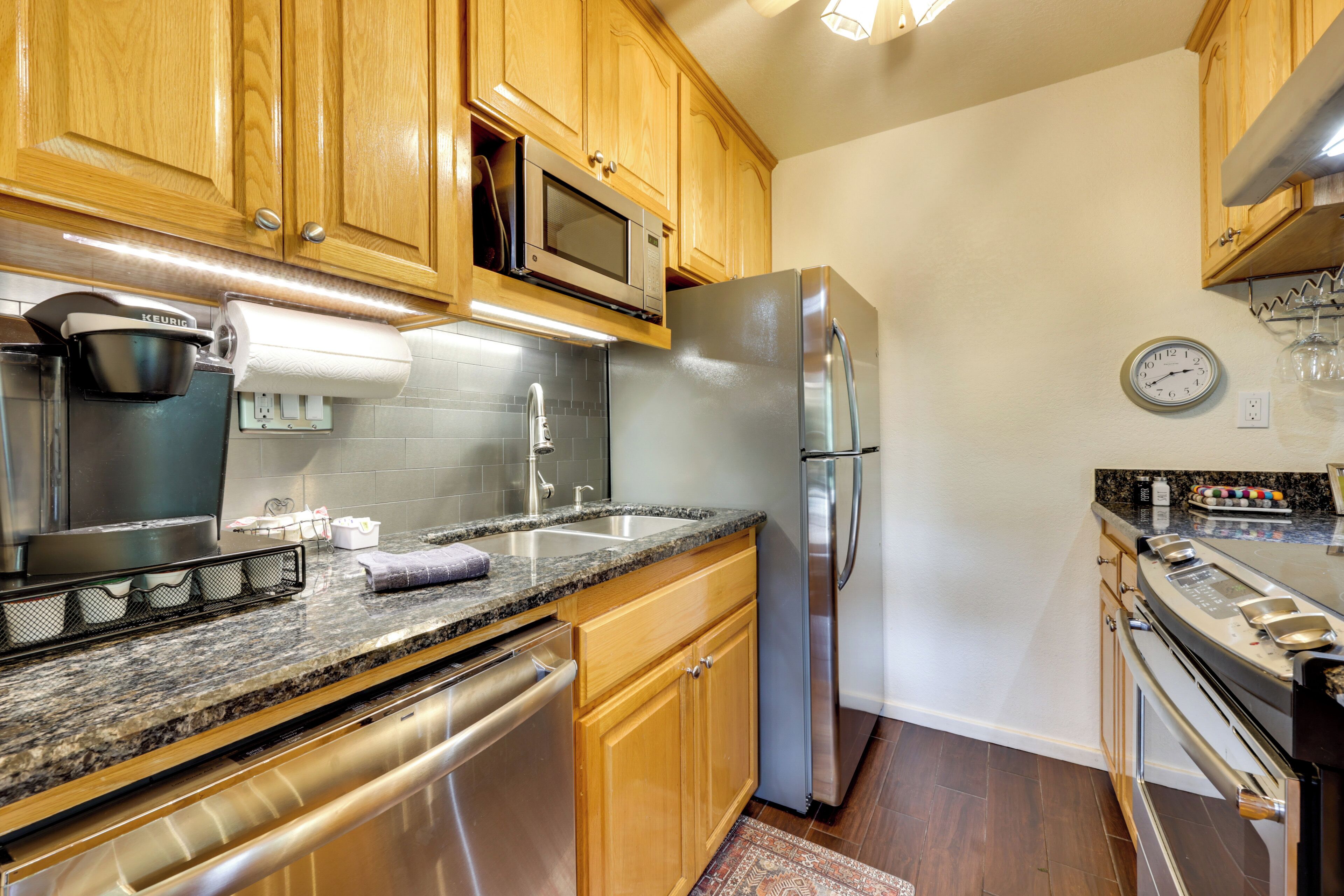 A kitchen with wooden cabinets, stainless steel appliances, a microwave, and a built-in oven.