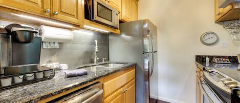 A kitchen with wooden cabinets, stainless steel appliances, a microwave, and a built-in oven.