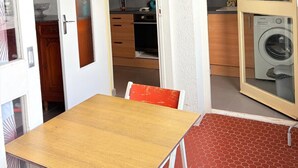 Une cuisine compacte avec des meubles en bois, un four encastré et un lave-linge.
