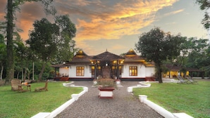 A traditional building with a symmetrical facade, a central entrance, and a gravel pathway leading to the entrance. - Alaya Stays by ELIVAAS Vembanad House  (Cherthala)