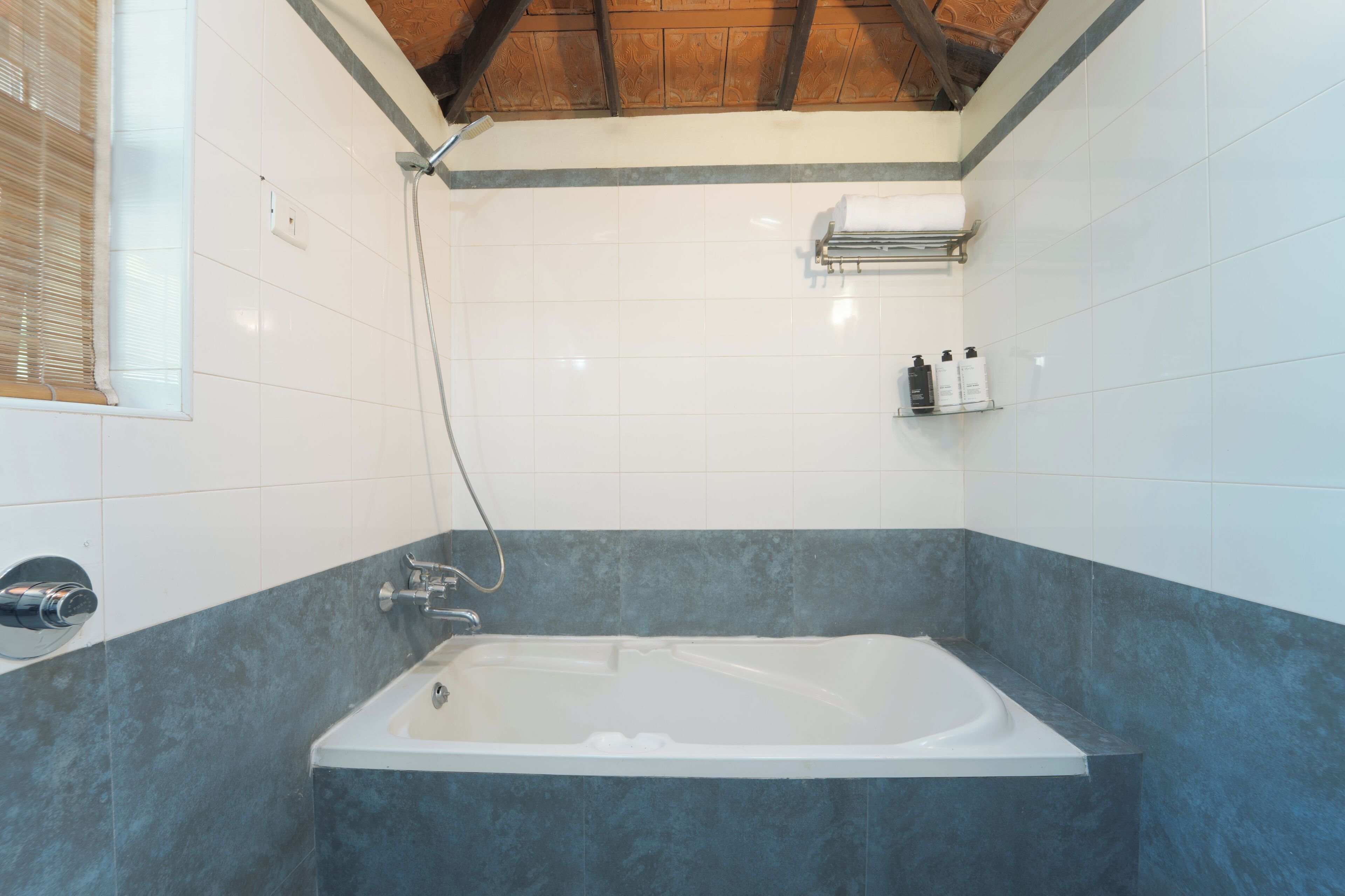 Uma casa de banho moderna com banheira, chuveiro e janela com persianas.