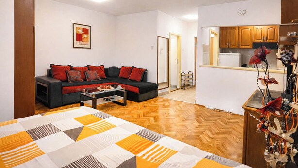Ein Wohnzimmer mit einer Couch, einem Couchtisch und einem Bett mit einem gemusterten Überwurf.