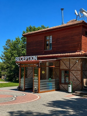 A reception area with a sign, a brick building, and a clear blue sky. - DIAMOND KORU HOTEL (Amasra)