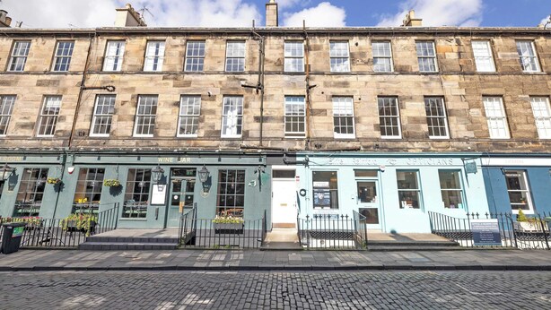 A row of traditional stone buildings with a pub and a medical practice on the ground floor. - Stylish West End 1-Bed | Prime Location (Edinburgh)