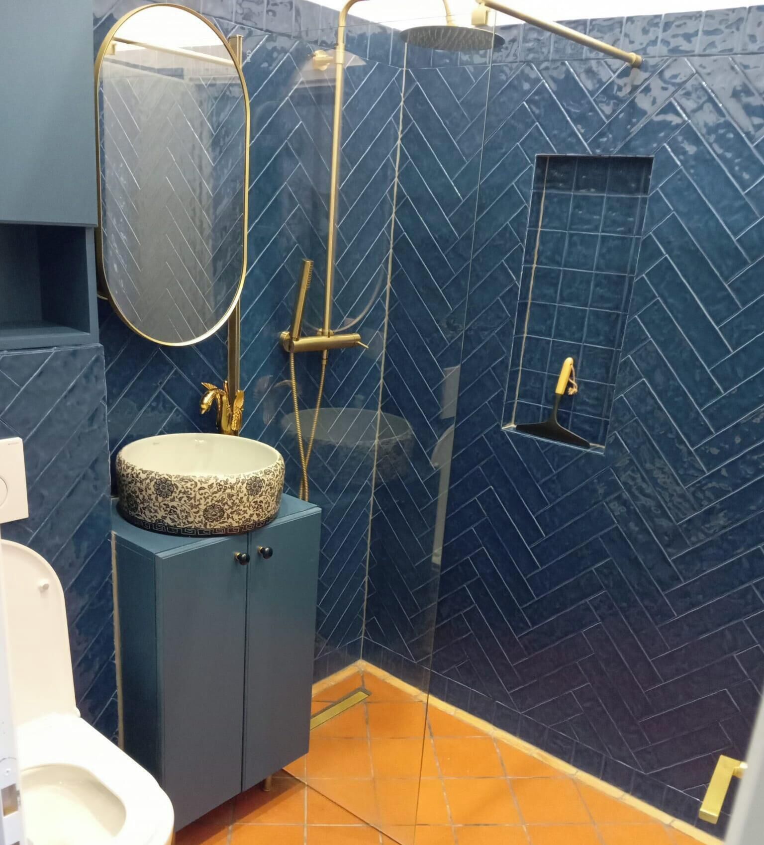 Un baño con lavamanos, espejo, ducha e inodoro.