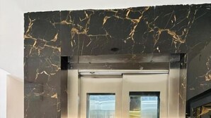 An elevator with a digital display, metallic interior, and marble-like wall design. - Hotel BN Palace  (Barakpur)