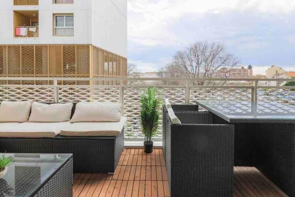 Una terraza en la azotea con un sofá, sillas y una pequeña mesa.