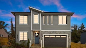 A two-story house with a garage, a front door with a wreath, and a well-maintained lawn. - New Build | Chef's Kitchen | Fireplace | 4BR (Charlotte)