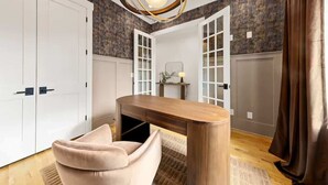 A room with a desk, a chair, a wardrobe, and a door with glass panels. - New Build | Chef's Kitchen | Fireplace | 4BR (Charlotte)