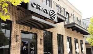 A brick building with a sign for 'CRAVHALL' indicating a hotel. - Wayfarer's Loft at The Sojourn: Brand New 2BR,  Sophisticated Retreat, Downtown Ocean Springs, Pet Friendly, Golf Cart Rental (Ocean Springs)