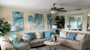 Ein Wohnzimmer mit zwei Sofas, einem Couchtisch und einem Deckenventilator.
