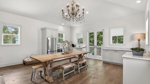A spacious kitchen with a wooden island, stainless steel appliances, and a chandelier. - Hobnob - Private Pool - Golf Cart (Santa Rosa Beach)