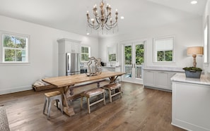 A spacious kitchen with a wooden island, stainless steel appliances, and a chandelier. - Hobnob - Private Pool - Golf Cart (Santa Rosa Beach)