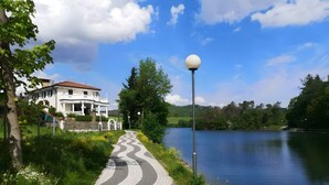 A pathway beside a lake with a white building and a lamp post. - diemelseeholiday Romantic Apartment with Balcony in the Sauerland near Willingen & Winterberg (Diemelsee)