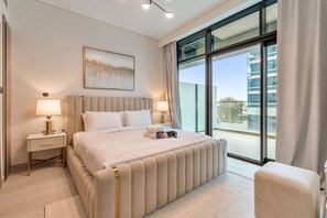 Ein Hotelzimmer mit einem großen Bett, zwei Nachttischen mit Lampen, einem Fenster mit Vorhängen und Blick auf ein Gebäude.