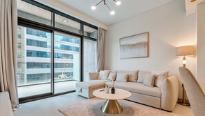 Moderni olohuone, jossa on sohva, pyöreä sohvapöytä ja lamppu.