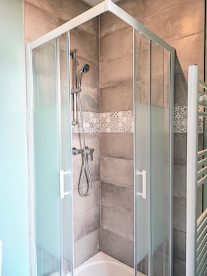 A glass-enclosed shower with a handheld showerhead and a handheld hose, a corner bathtub, and a tiled wall. - Manoir des Lumi res 5 ch Terrasse Wifi 5 sdb (Roubaix)