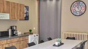 A modern kitchen with wooden cabinets, a coffee maker, and a washing machine. - Manoir des Lumi res 5 ch Terrasse Wifi 5 sdb (Roubaix)