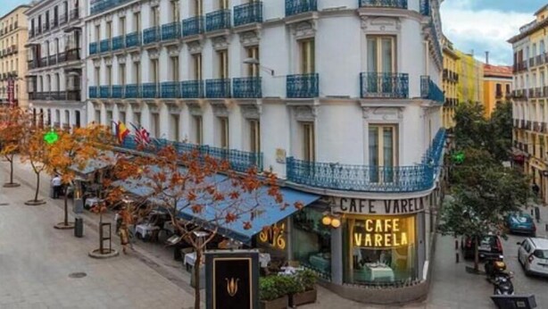 Ein Eckgebäude mit einem Schild für 'HOTEL PRECIOS' und 'CAFE VARELA' im Erdgeschoss.