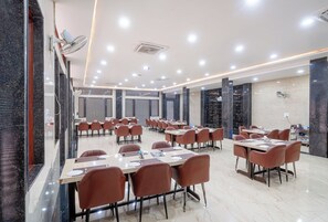 Un salón de conferencias con mesas y sillas, un ventilador de techo y un piso de mármol.