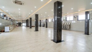 A spacious lobby with marble flooring, large pillars, and a reception desk. - Hotel Entry Point (Raipur)