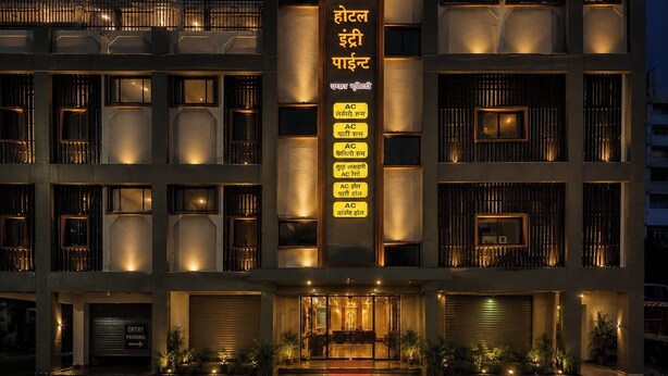 A multi-story hotel with a central vertical sign listing amenities such as AC, parking, and a spa. - Hotel Entry Point (Raipur)