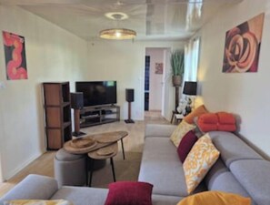 Una sala de estar con sofá, televisor y una mesita.