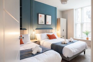 Ein Hotelzimmer mit zwei Betten, einem großen Fenster und Bildern an der Wand.