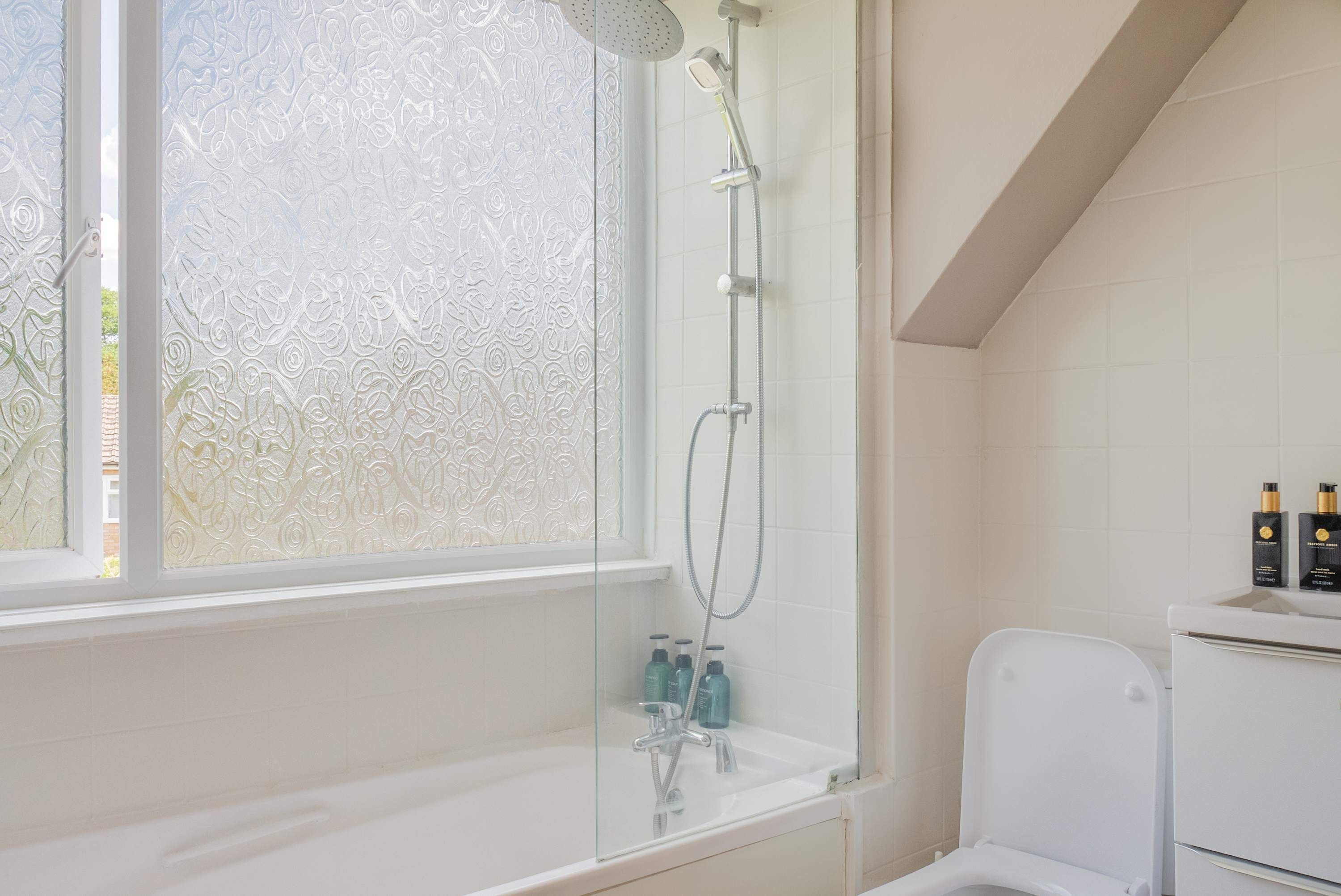 Une salle de bain avec une douche à parois de verre, une baignoire blanche et des toilettes.