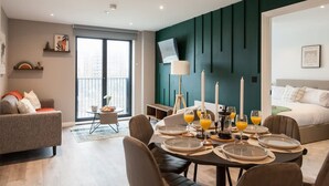 Een moderne hotelkamer met een eethoek, een bank en een bed.